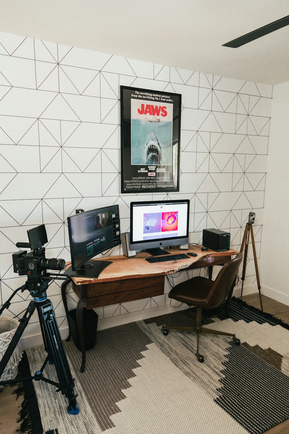 Oficina en casa con dos monitores, cámara web y escritorio de borde vivo.