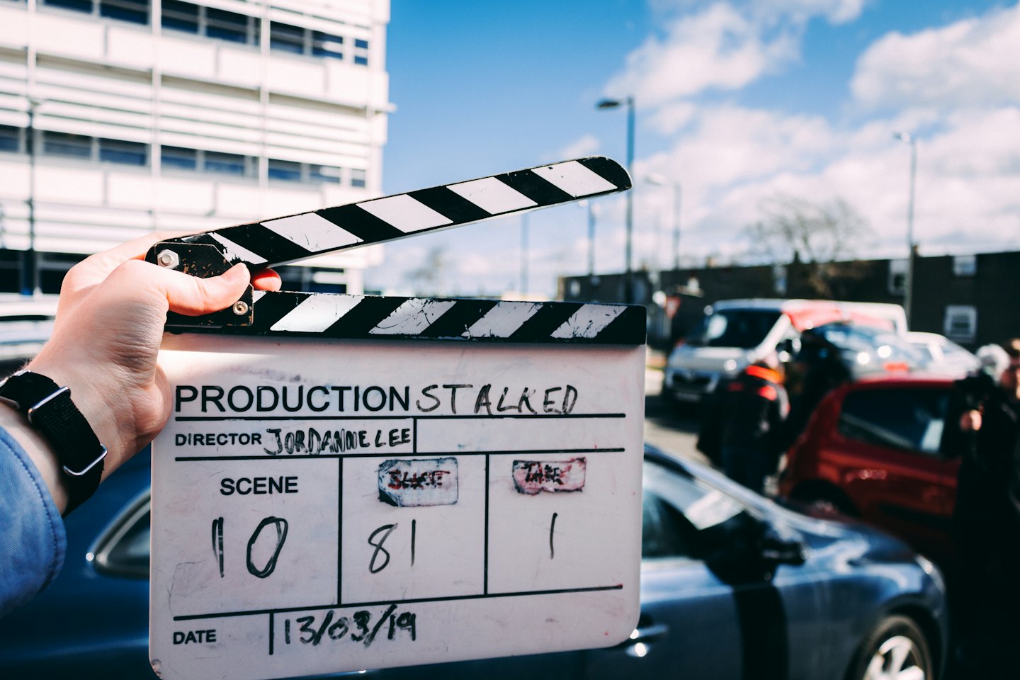 Persona sujetando una claqueta de cine en un día soleado.