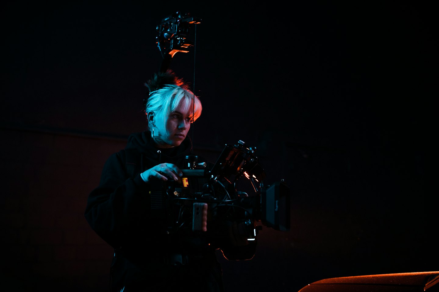 Videógrafo profesional operando un complejo equipo de cámara en un estudio.